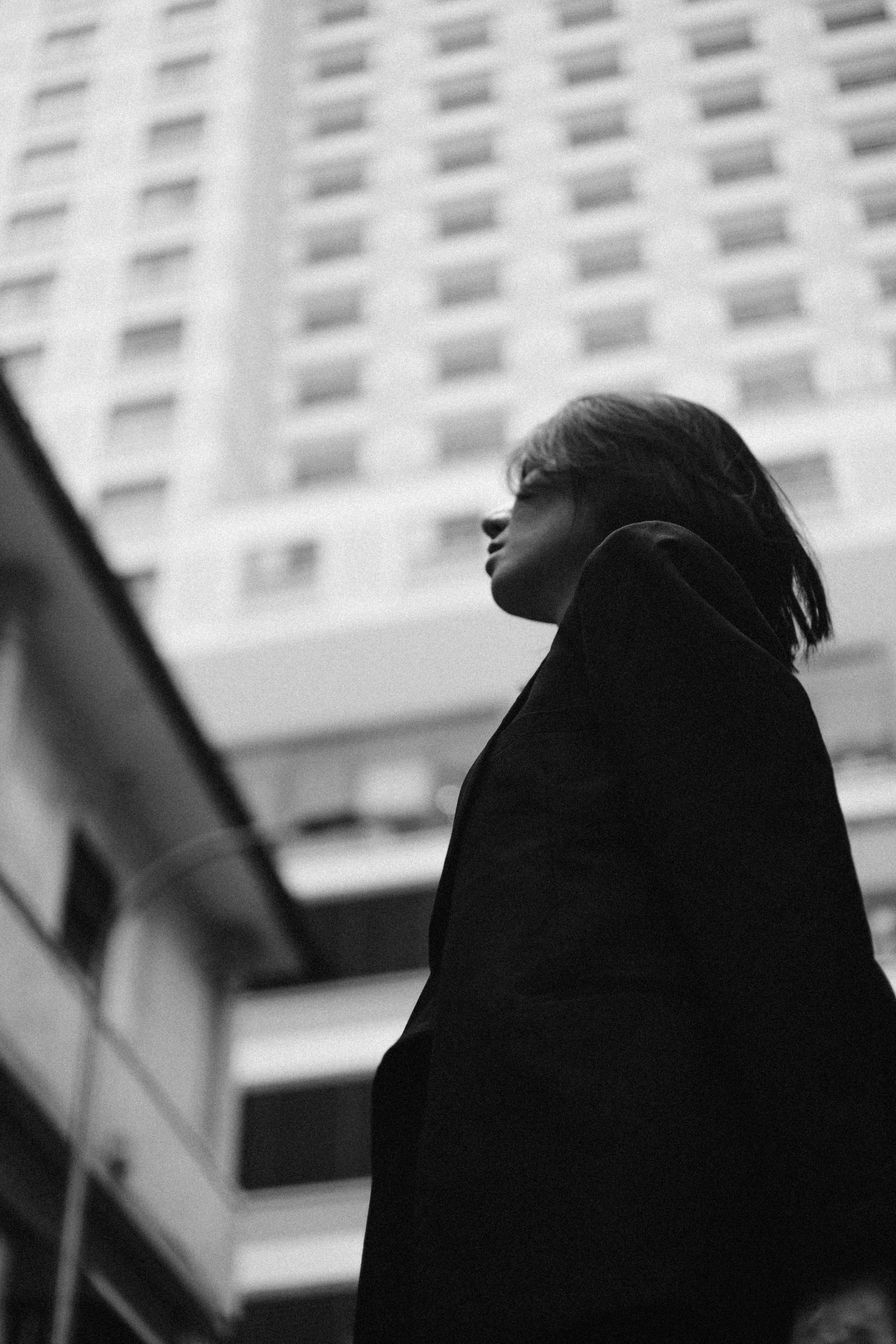A modern black and white portrait of a woman in an urban environment.