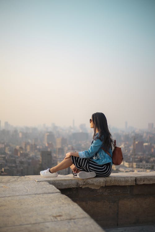 女人坐在建筑物的边缘