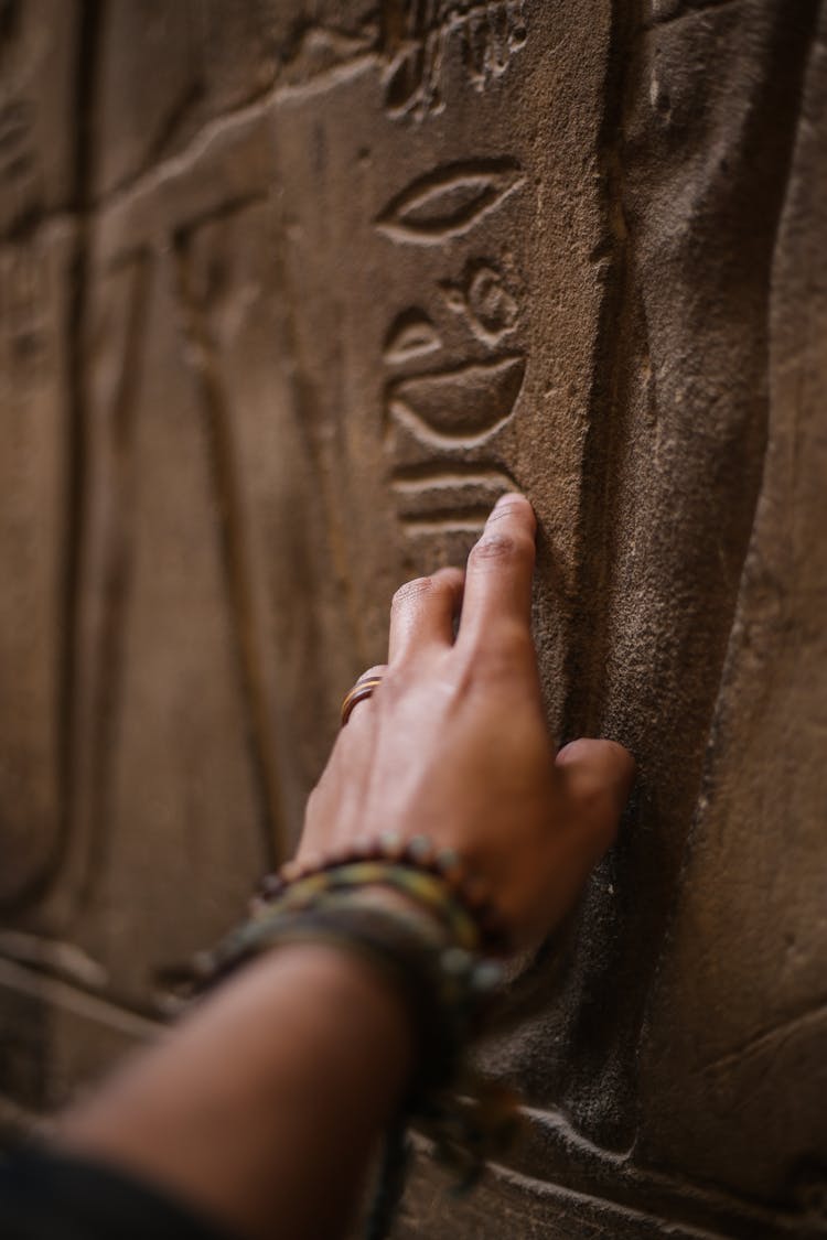 Close-Up Photo Of Person Touching Inscribed Wall