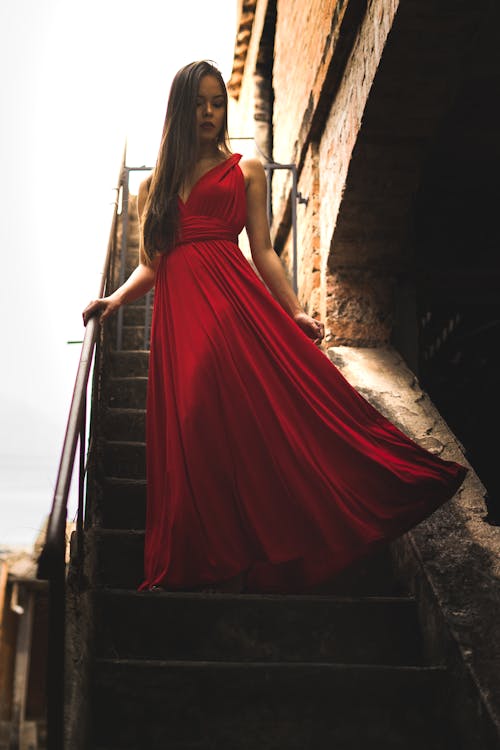 Gratis Mujer, Llevando, Vestido Rojo, Posición, En, Escalera Foto de stock