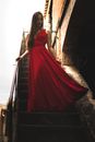 Woman Wearing Red Dress Standing on Staircase