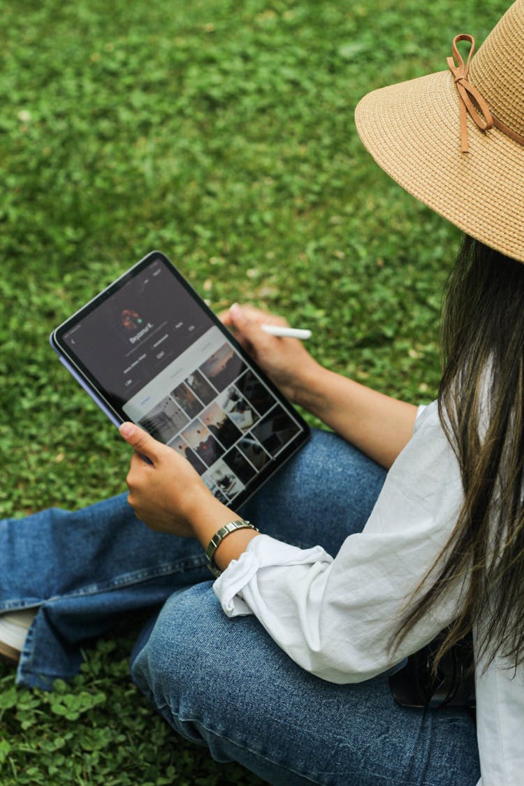 Woman Sitting On Lawn With Tablet