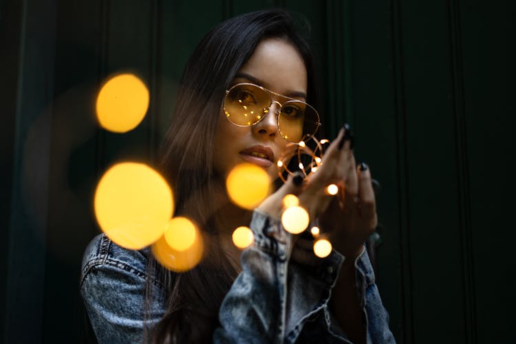 Close-Up Photo Of Woman Holding String Lights