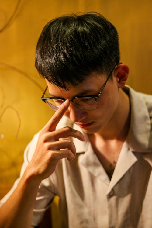 Young Man Fixing His Eyeglasses 