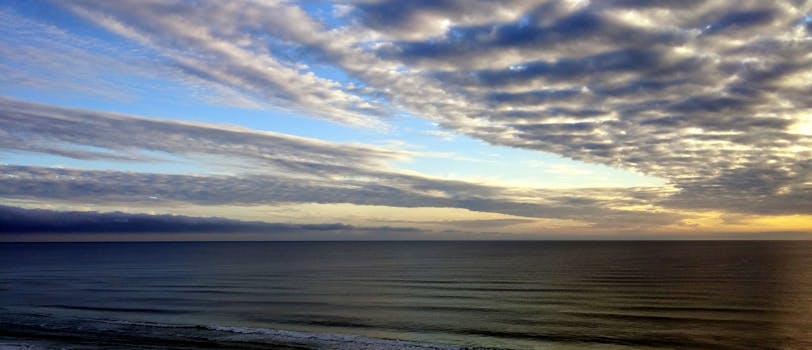 黎明时分，云层与宁静的海洋地平线构成令人叹为观止的海滨景色