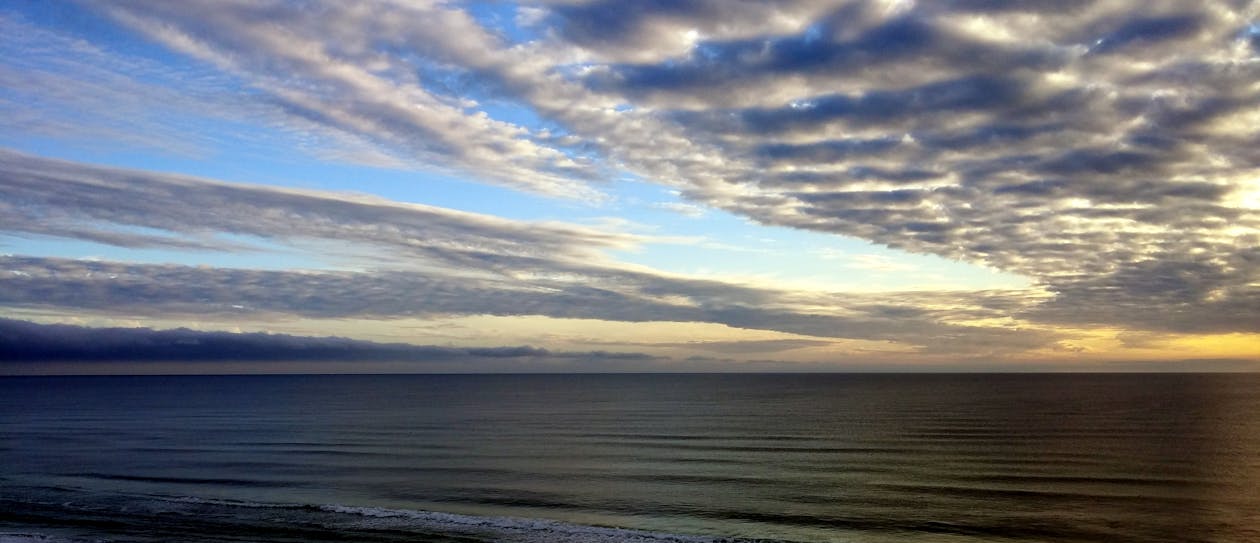 免費 黎明時分，藍色的大海下的白色天空 圖庫相片