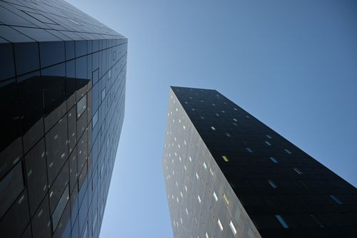 Free Low angle view of sleek skyscrapers reaching towards a clear blue sky. Stock Photo