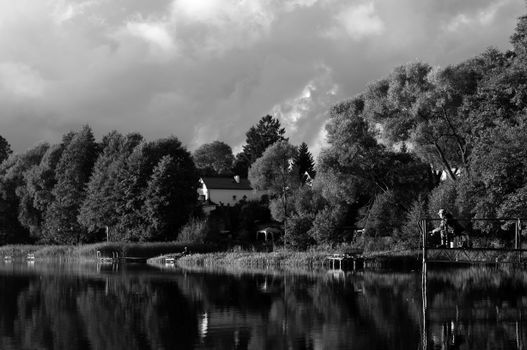 A black and white photo of a lake with trees