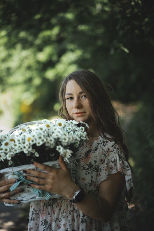 Long-Haired Brunette Holding a Basket of Freshly Picked Wildflowers