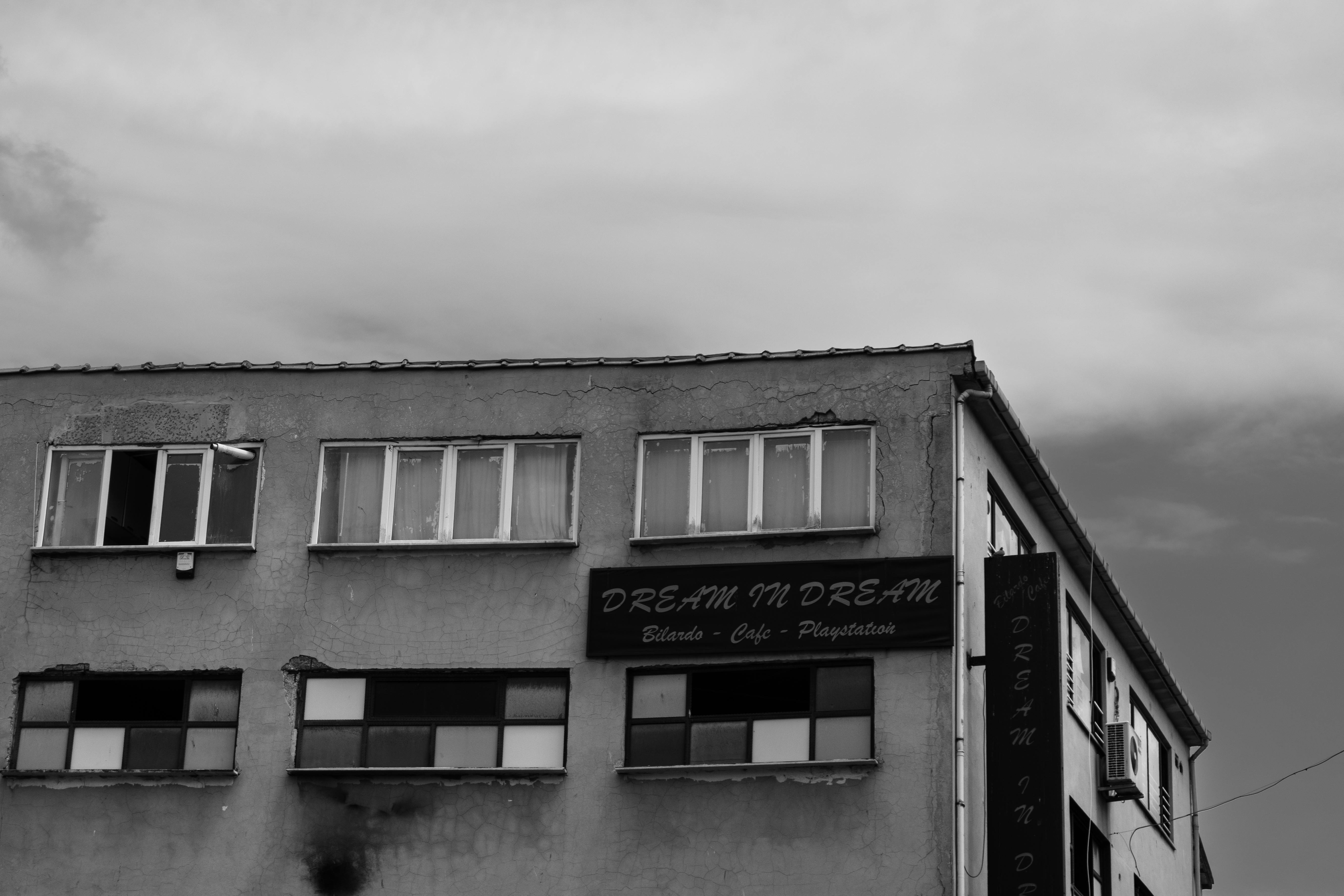 Grayscale photo of man standing near window photo – Free Cloud