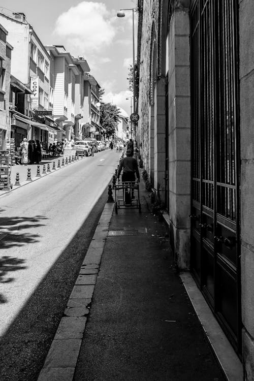 Busy Street with a Senior Man Pulling a Cart in the Foreground