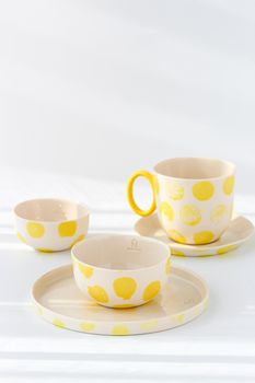 Charming ceramic set with yellow polka dots on a white background, perfect for kitchens.