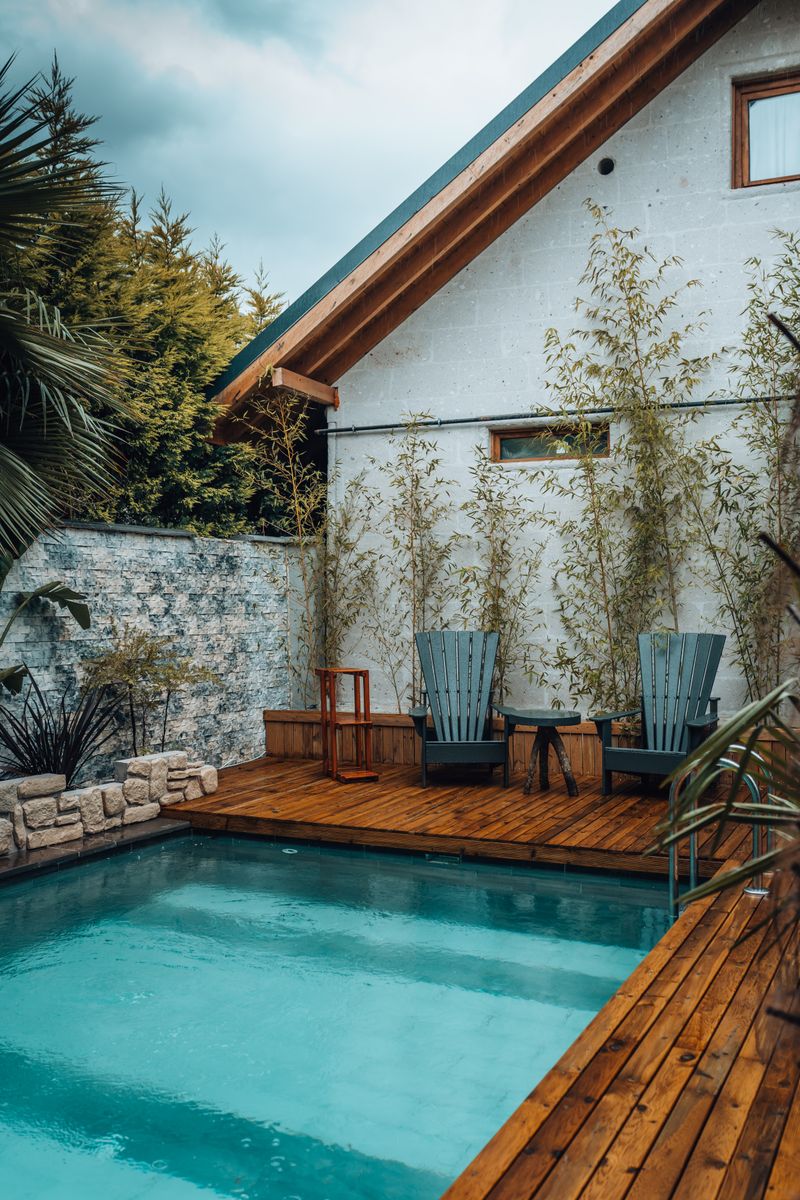 Pool with a natural wood deck and lounge seating