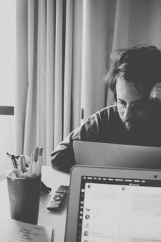 Black and white portrait of a man working on a laptop in an office in Rio de Janeiro.