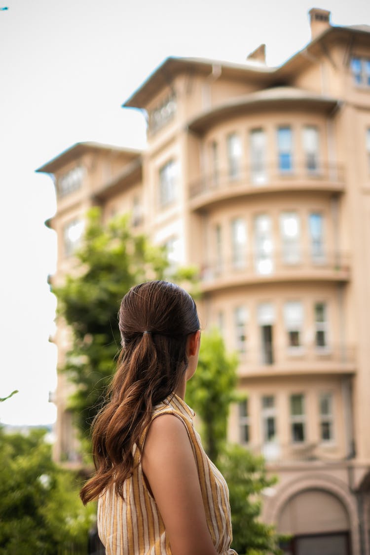 Woman Looking Back At Apartment Building