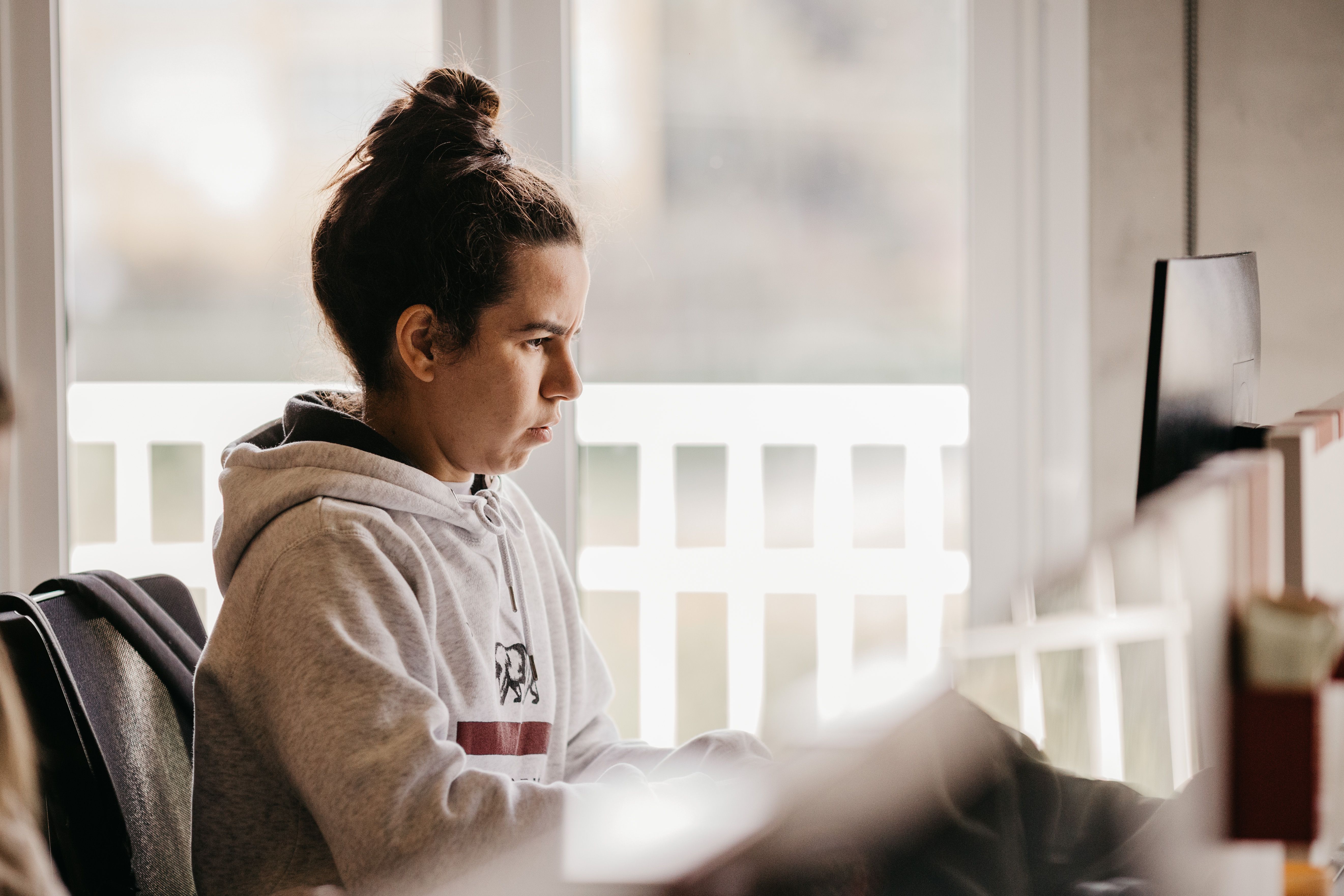person chewing gum while working at a desk with focused expression