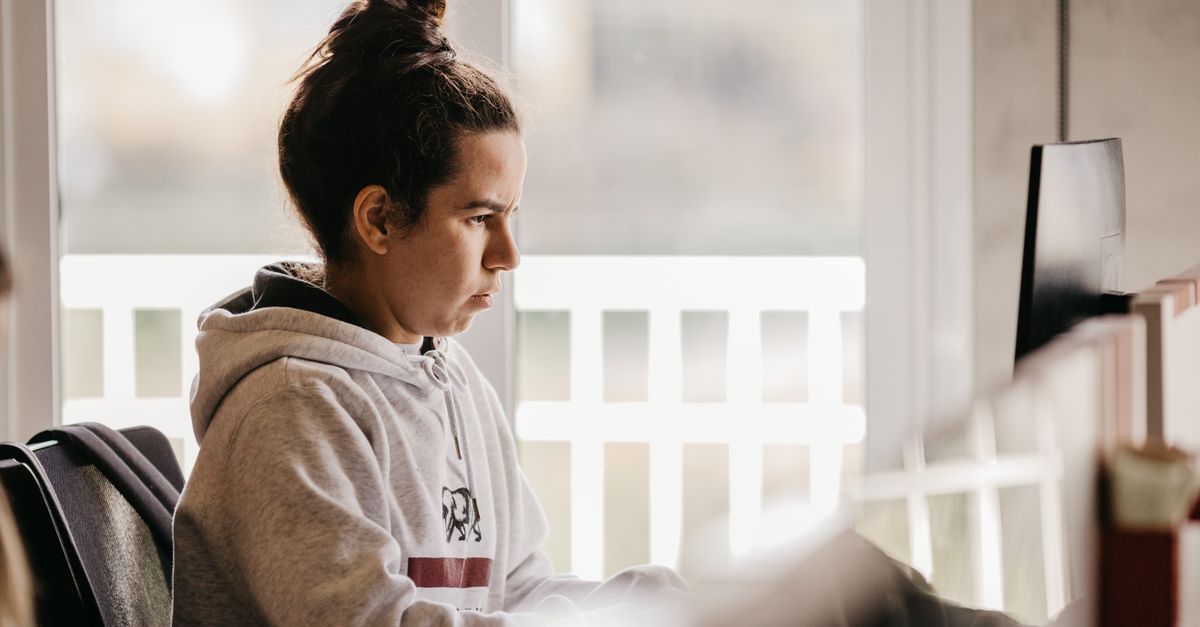 person chewing gum while working at a desk with focused expression