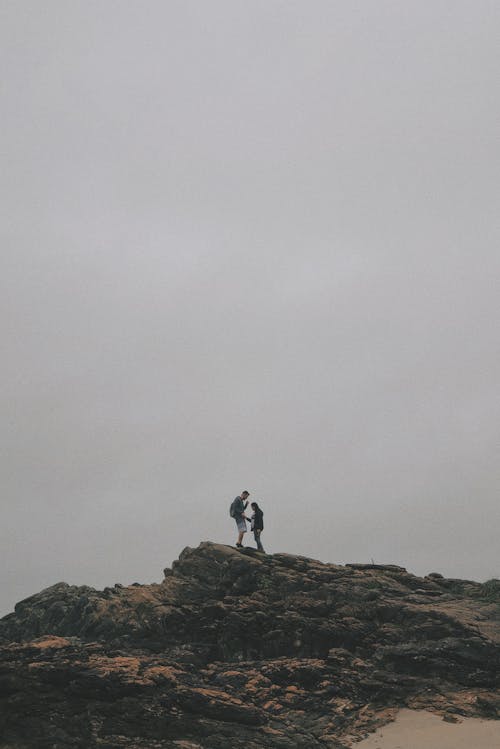 Hombre Y Mujer De Pie Sobre Una Roca Bajo Un Cielo Blanco