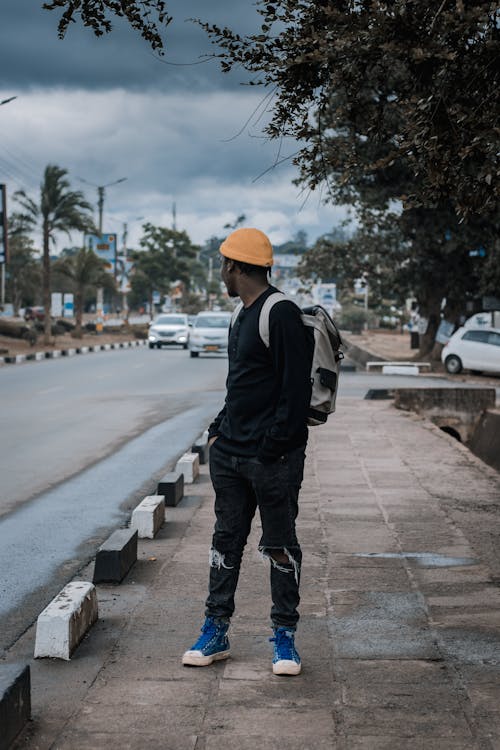 Man in Black Clothes Standing on Sidewalk