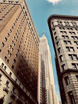 A stunning upward view of New York City's iconic skyscrapers against a clear blue sky.