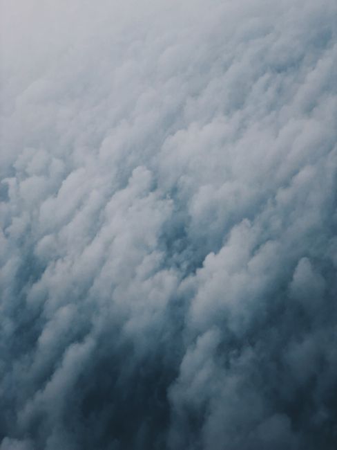 A stunning aerial view showcasing fluffy clouds and a serene blue sky, perfect for nature and travel themes.