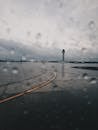 窗外，雨滴在多云天空下俯瞰着机场跑道和控制塔