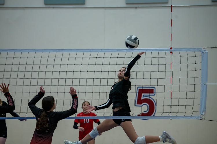 Teenager Girls Playing Volleyball At An Indoor Court