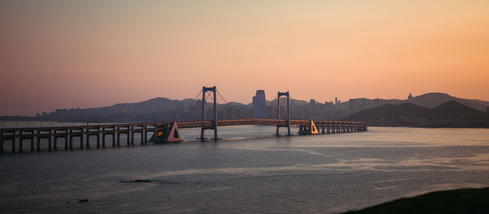 Explore the scenic beauty of Dalian's Xinghai Bay Bridge bathed in sunset light. — flights from Beijing to Dalian