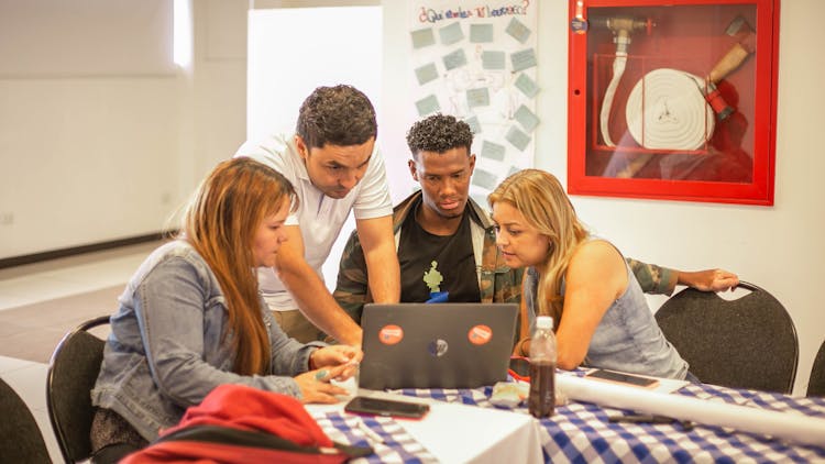 Group Of People Working On A Laptop At A Class