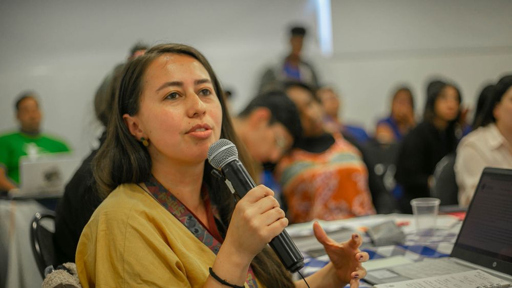 Learner speaking confidently into a microphone during a classroom discussion