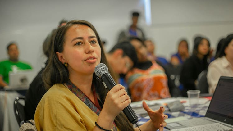 Young Woman Speaking On A Microphone In A Class 