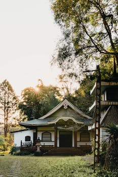 日落时分，一座宁静的日式传统房屋被郁郁葱葱的绿植环绕，坐落在京都