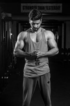 Black and white portrait of a muscled man in gym, embodying strength and focus.