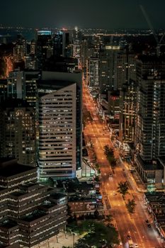 Capture of Toronto's vibrant cityscape at night, showcasing brightly lit streets and towering skyscrapers.