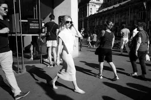 Woman Walking on Sunlit Pavement