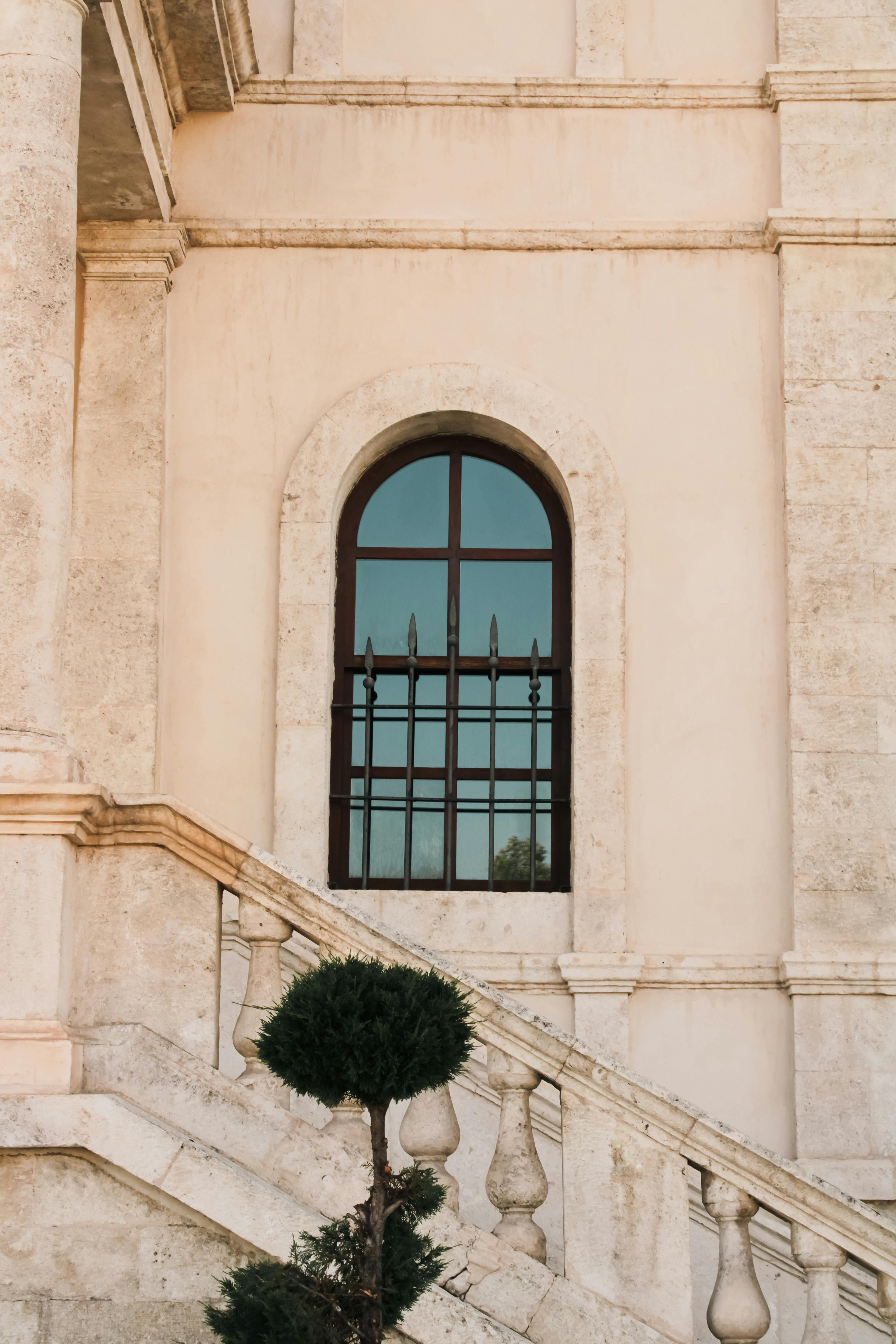 A sophisticated exterior scene showcasing a stone staircase and arched window, ideal for architectural themes.
