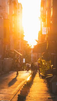 Street scene in Istanbul during sunset, capturing silhouettes and vibrant city life.