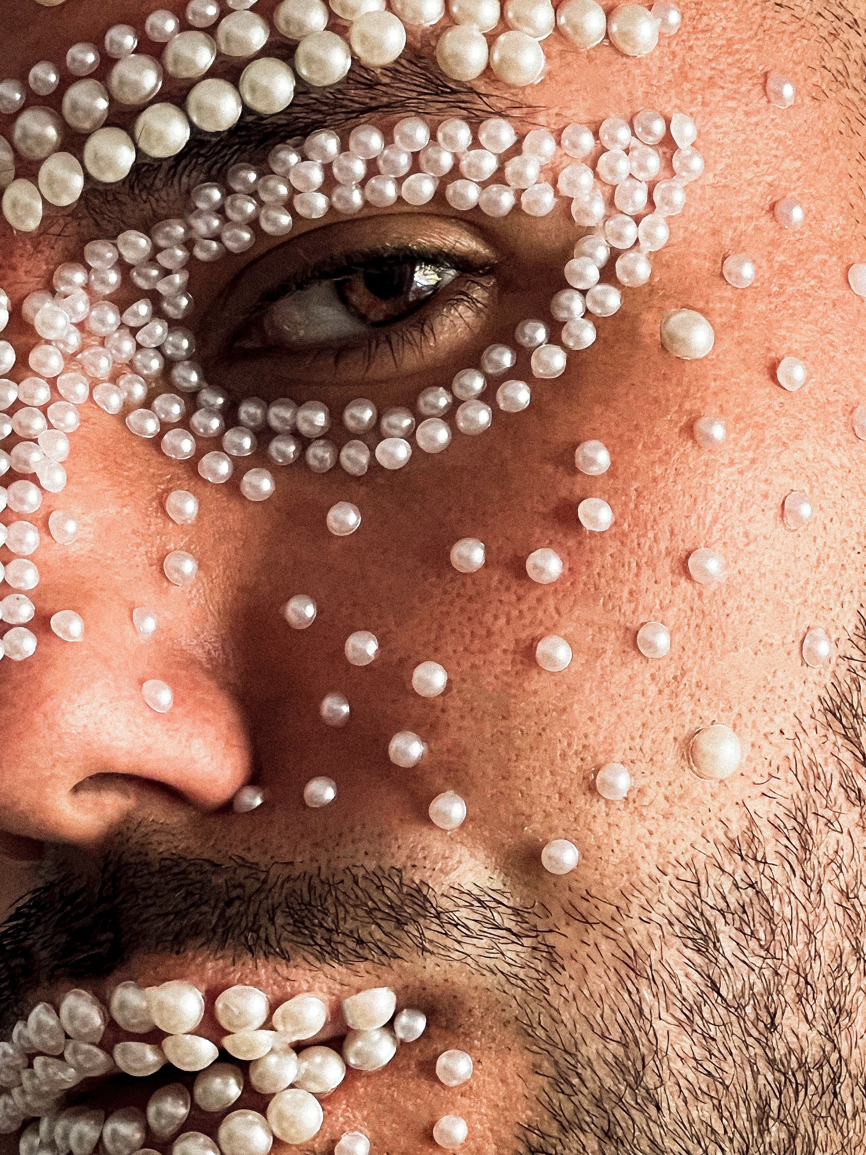 Fotomural Primer plano artístico de la cara de un hombre adornada con pegatinas de perla en patrones únicos.