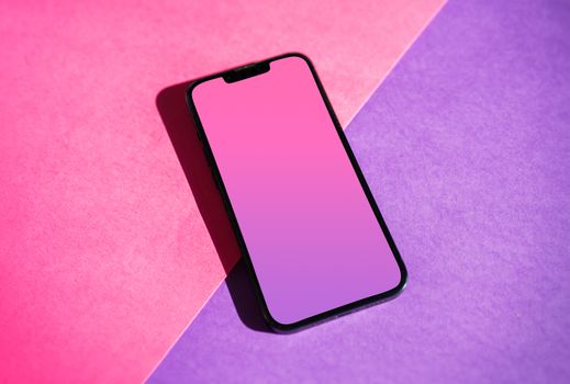Smartphone on a vibrant pink and purple gradient background, perfect for tech mockups.