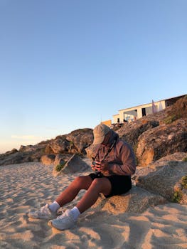 Photographer enjoying a calm evening on a rocky beach, capturing moments in the golden light.