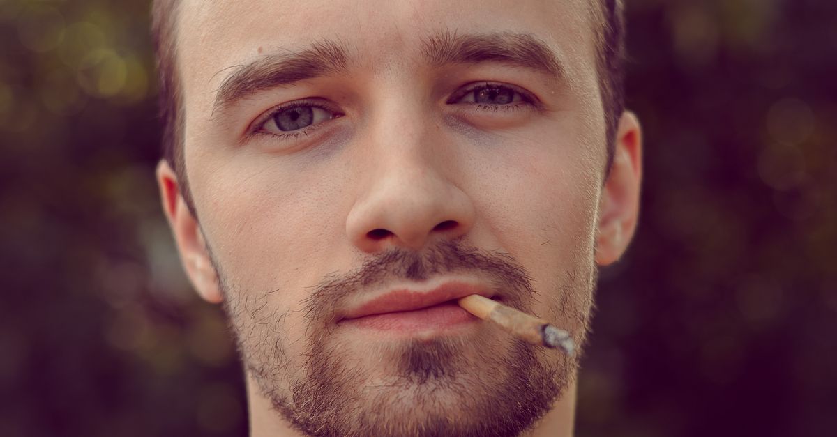 A young man with a beard, natural outdoor portrait in warm light