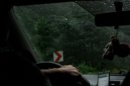 View from inside a car during rain, focusing on navigation and wet windshield.