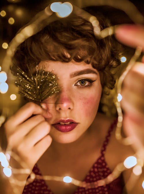 Selective Focus Photography of Woman Surrounded by String Lights