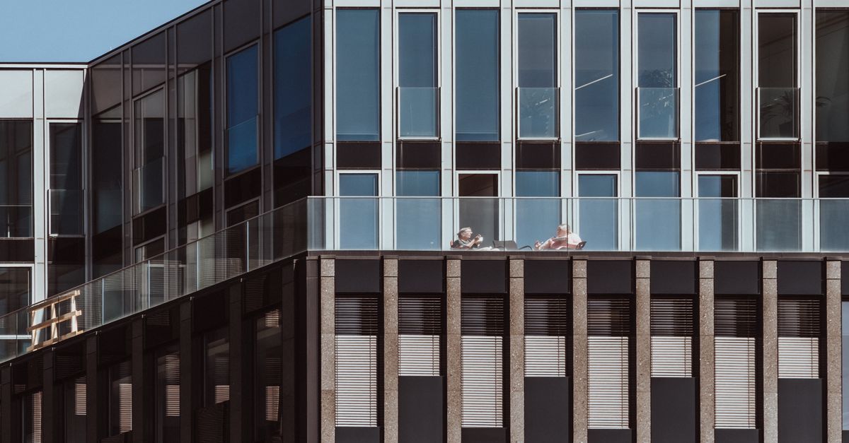 Modern architecture showcasing a geometric glass and steel facade with a terrace view.
