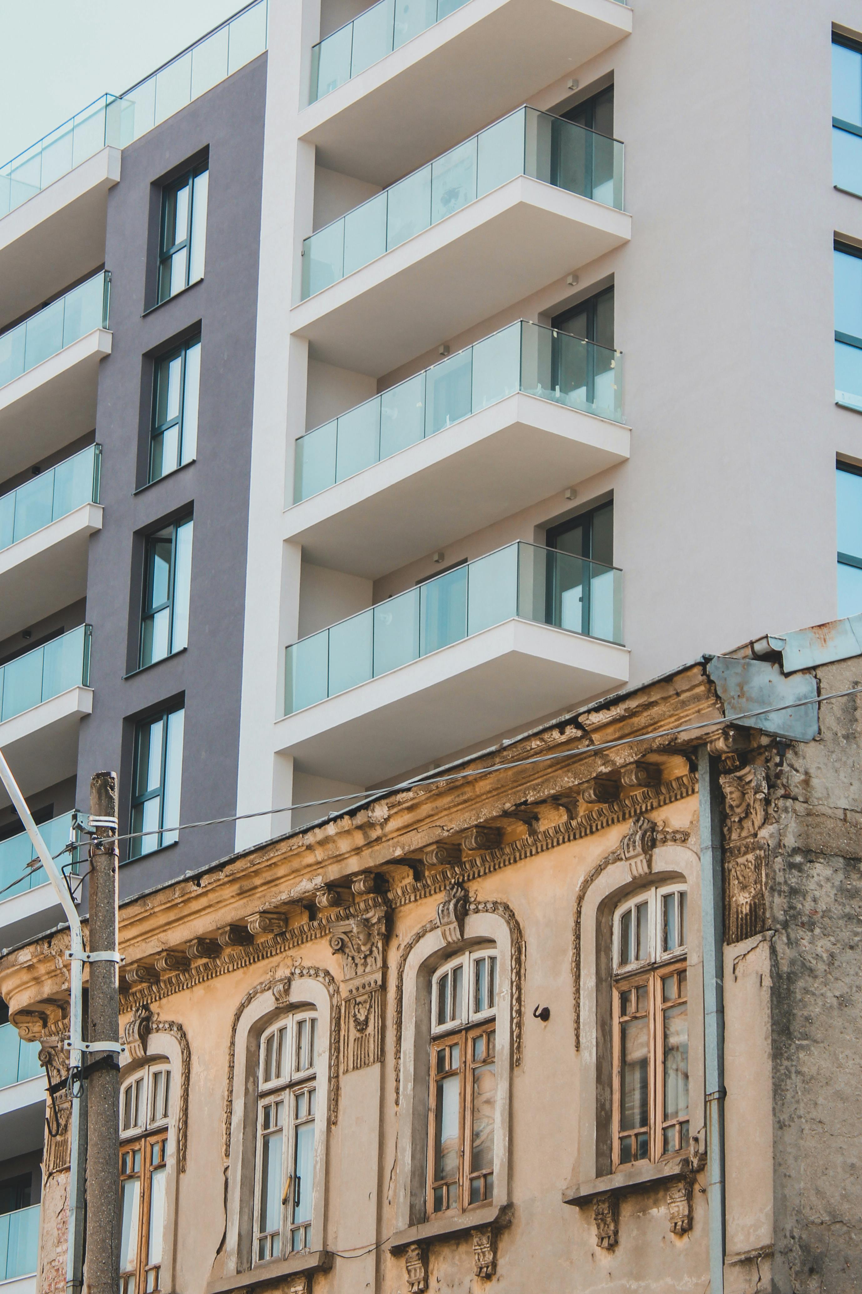 Modern and old buildings juxtaposed in an urban residential area showcasing architectural contrast.