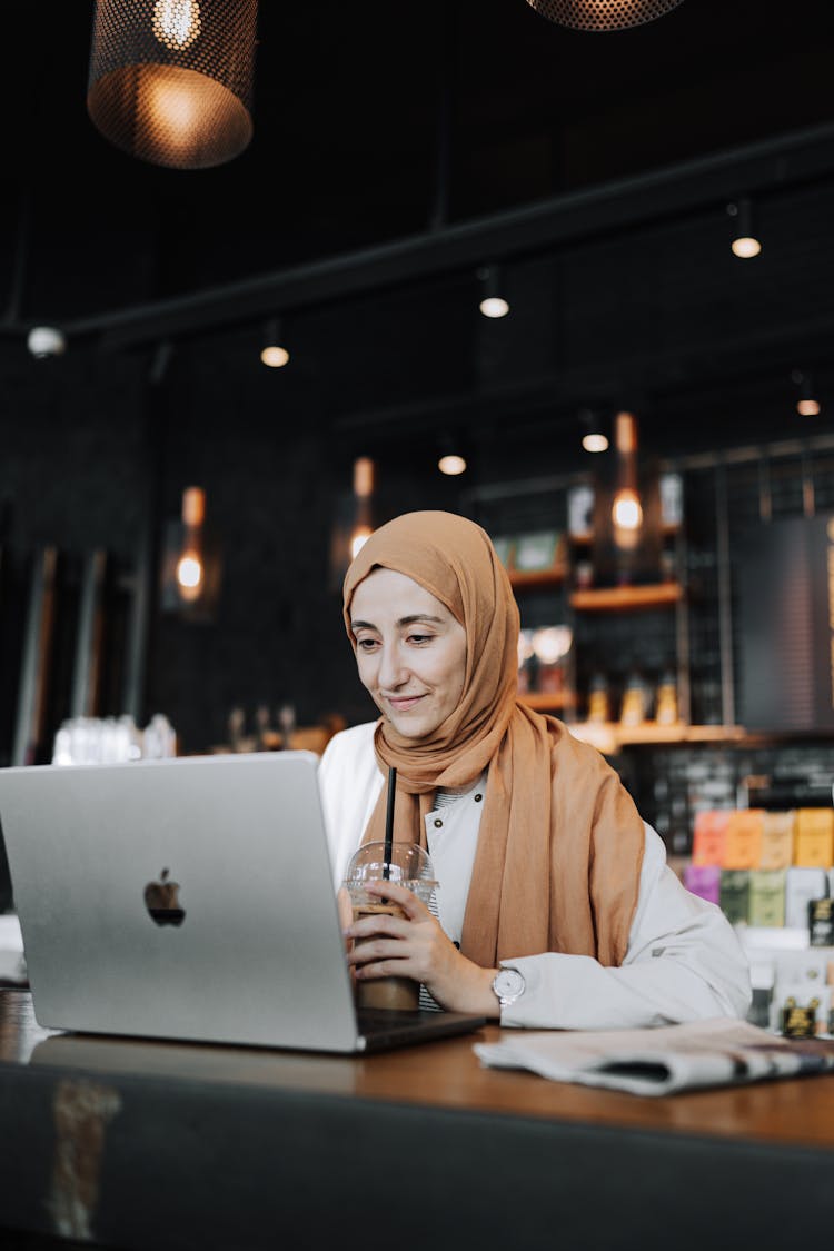 Woman Using Laptop At Cafe