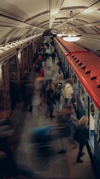 Blurred motion of commuters at a busy subway station platform.