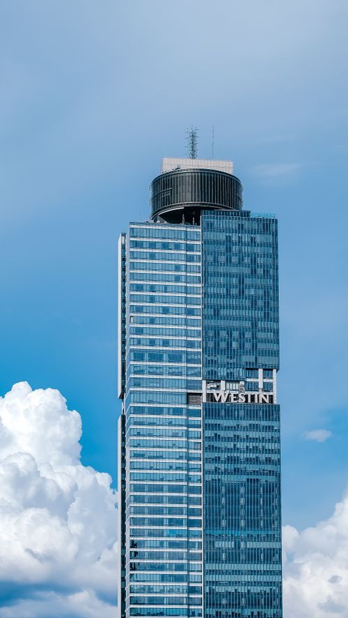 Free Tall modern skyscraper with blue glass facade against a clear sky, capturing urban architecture. Stock Photo