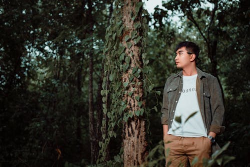 A man standing in the woods wearing a jacket