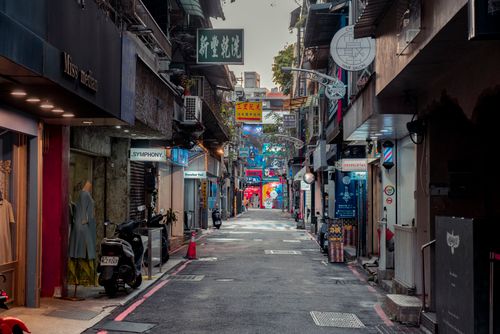 Free Explore a bustling narrow city street with vibrant signs and shops, capturing urban life. Stock Photo